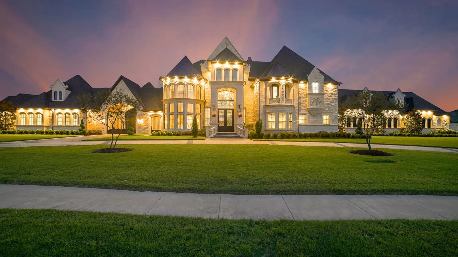 Estate home lit at dusk